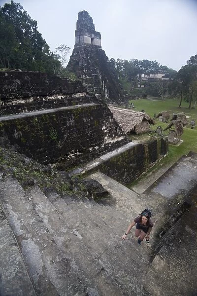 Woman climbing stairs at Mayan archaeological site, Tikal, UNESCO World Heritage Site, Guatemala, Central America