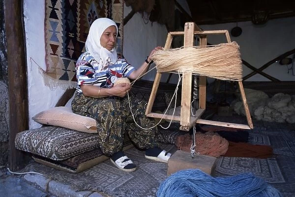 Woman gathering dyed wool in carpet workshop