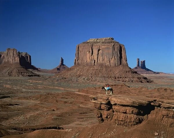 A woman on horseback in the desert with rock formations