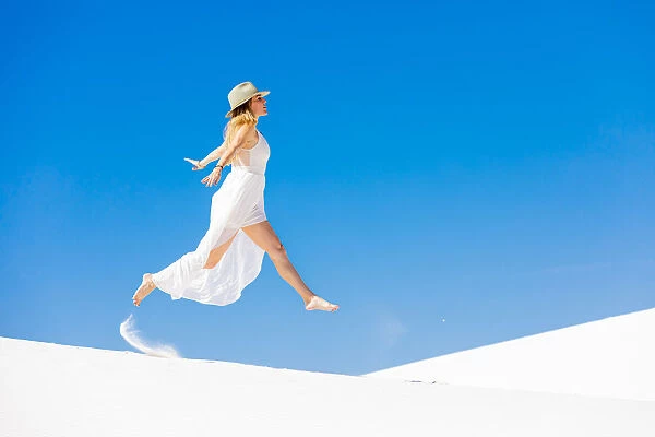 Woman jumping on the Gypsum Sand Dune, White Sands, New Mexico, United States of America