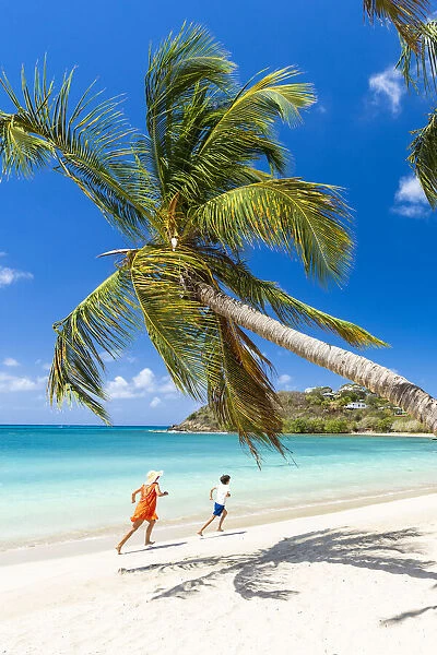 Woman and little boy having fun running on a palm fringed beach, Antigua, West Indies, Caribbean, Central America