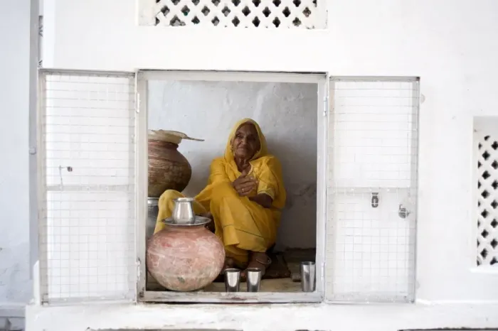 Framed Print : Woman offering drinking water to devotees at Jagdish temple, Udaipur, Rajasthan