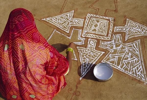 Woman painting a Mandala design on the ground