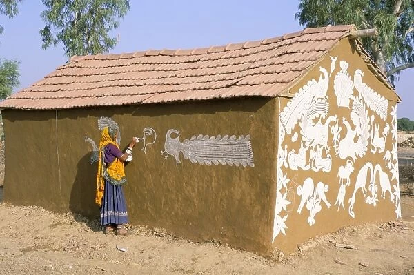 Woman painting walls of a house in a village near Jodhpur