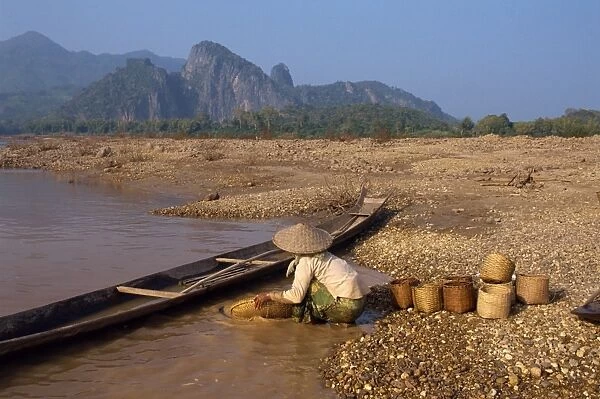 Woman panning for gold in the Mekong River