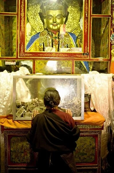 Woman pays respect at Meru Nyingba Buddhist monastery, Bharkor, Lhasa, Tibet, China, Asia