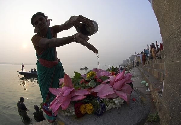 Woman pouring water over flowers on an altar as a religious ritual