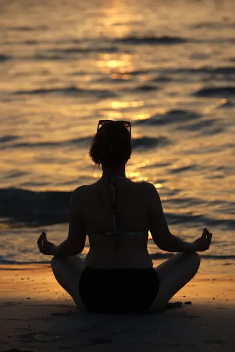 Framed Print : Woman practising yoga meditation on beach at sunset as concept for silence and relaxation