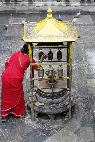 Woman and prayer wheels, Golden Temple, Patan, Nepal, Asia