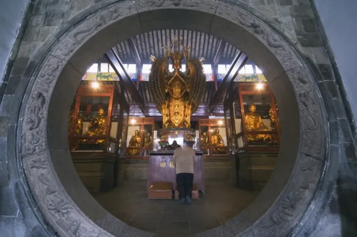 Framed Print : A woman praying in front of an arched entrance at West Garden Buddhist Temple Framed Print : A woman praying in front of an arched entrance at West Garden Buddhist Temple