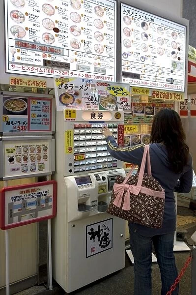 Woman purchasing meal tickets from a vending machine at a restaurant in Dotonbori