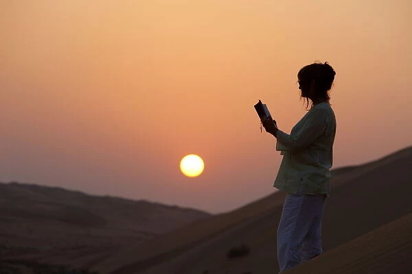 Woman reading the Bible in the desert, Abu Dhabi, United Arab Emirates, Middle East