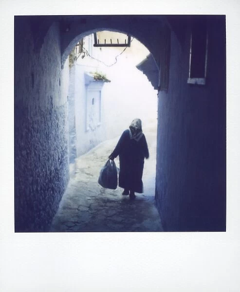 Woman in semi-silhouette walking through archway