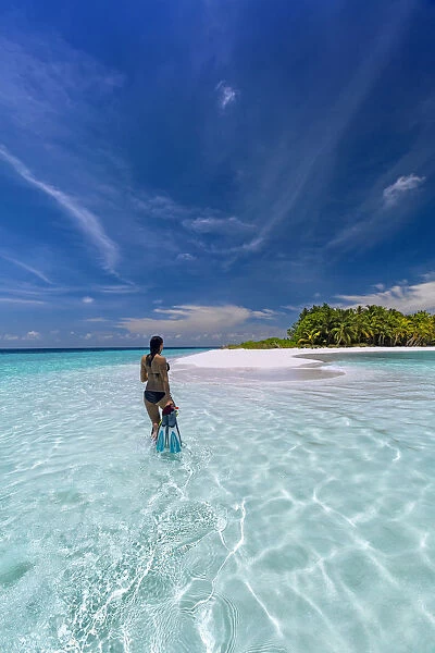 Woman with snorkelling gear on tropical beach, The Maldives, Indian Ocean, Asia
