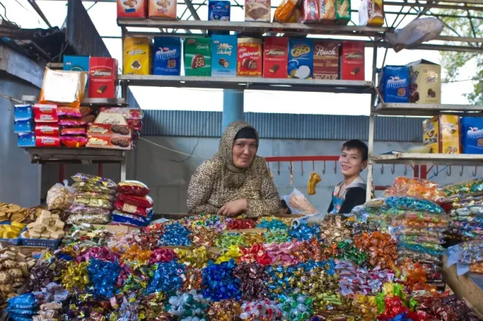 Framed Print : Woman and her son selling sweets on a market stand in the Bazaar of Osh Framed Print : Woman and her son selling sweets on a market stand in the Bazaar of Osh