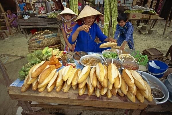 Woman street vendor selling French bread sandwiches