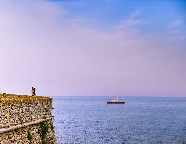 Woman alone at sunset next to the sea, Antibes, Cote d Azur, French Riviera, France