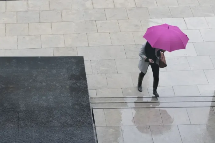 Framed Print : Woman with umbrella and mobile phone walking up steps to Auckland Art Gallery, Auckland