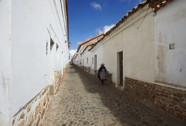 Woman walking along alleyway, Sucre, UNESCO World Heritage Site, Bolivia, South America