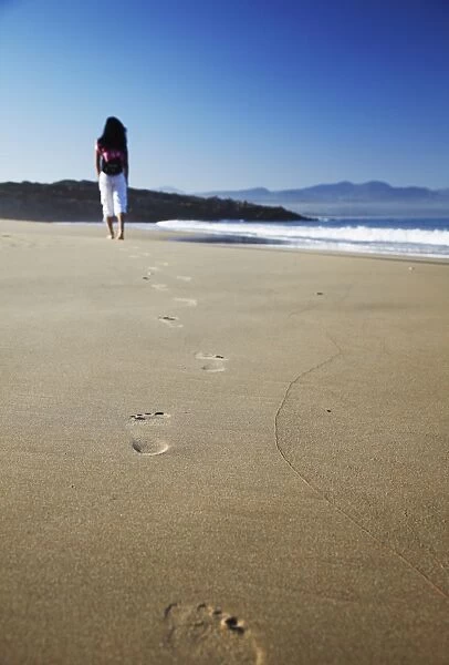 Woman walking on beach, Plettenberg Bay, Western Cape, South Africa, Africa