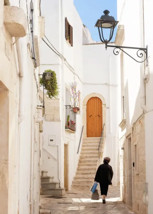 Framed Print : Woman walking in a narrow street in the Old Town, Locorotondu, Puglia, Italy, Europe