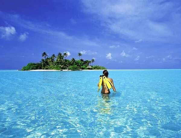 Woman walking with snorkelling equipment to Rihiveli island, Maldives, Indian Ocean, Asia