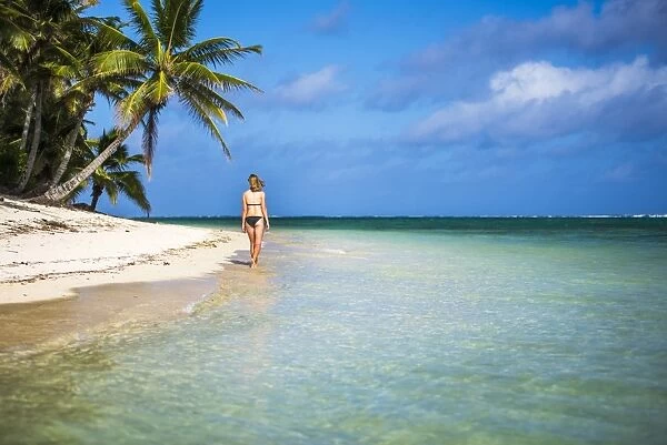 Woman walking along a tropical beach, Rarotonga Island, Cook Islands, South Pacific
