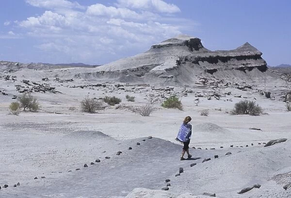 Woman walks to Cancha de Bochas (Expanse of circular stones) in Parque Provincial Ischigualasto