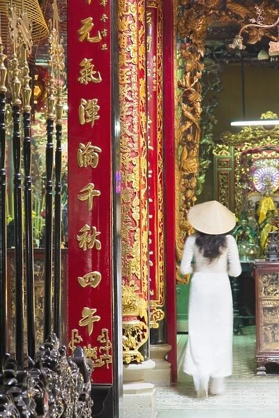 Woman wearing ao dai dress at Phuoc An Hoi Quan Pagoda, Cholon, Ho Chi Minh City