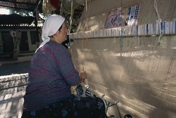 Woman weaving wool carpet on a loom in a workshop at Kusadasi