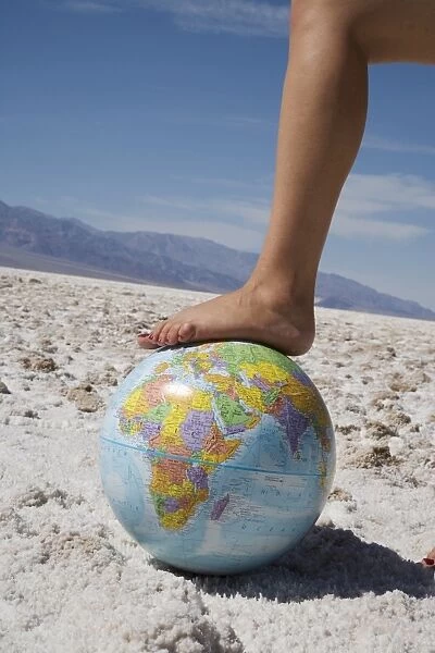 Womans foot on globe