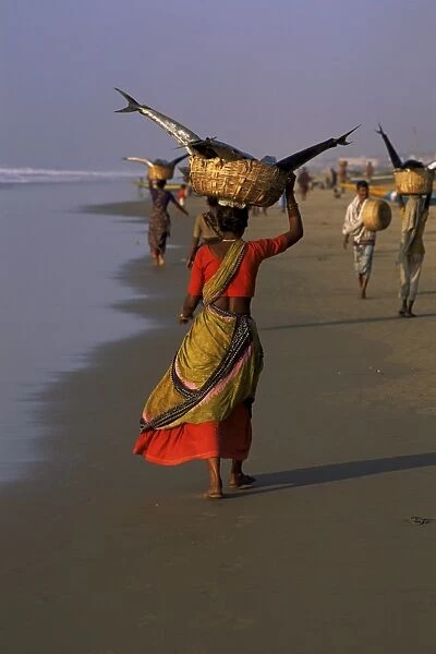 Women carrying fish catch to the market of fishing village