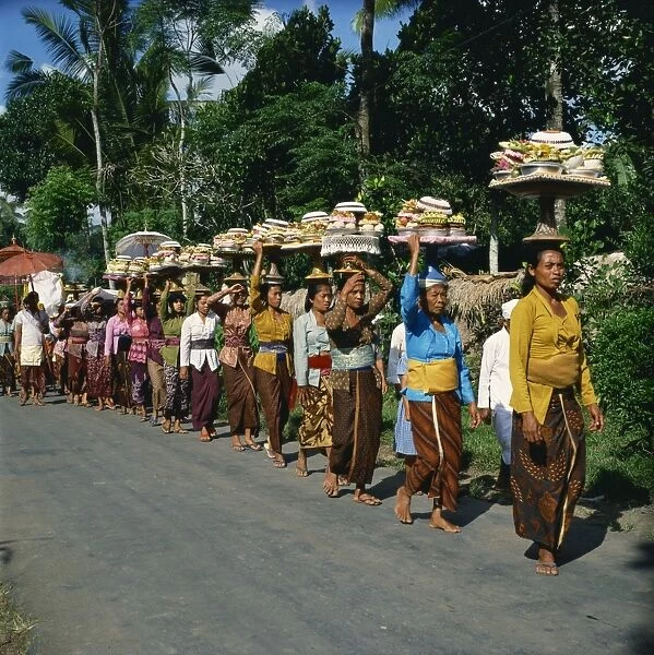 Women carrying offerings on their heads in a religious
