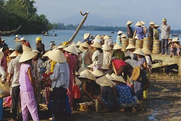 Women in conical hats at the fish market by the Thu
