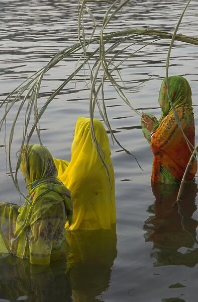 Three women pilgrims in saris making Puja celebration