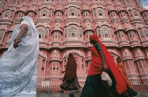 Women in saris walking past the Palace of the Winds (Hawa Mahal)