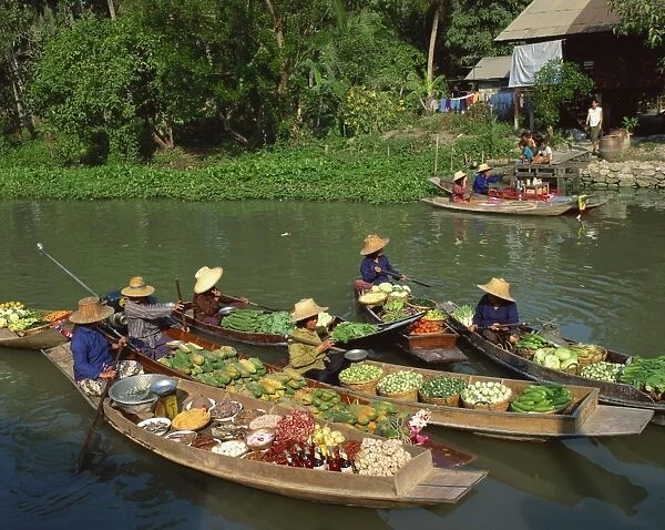 Women in straw hats in boats loaded with fruit