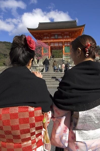 Two women in traditional kimonos walking towards the