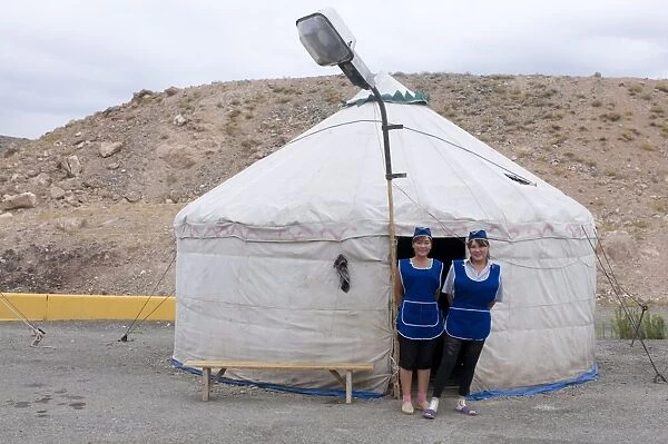 Women in front of a traditional yurt acting as a restaurant with a street lamp waiting for customers, Charyn Canyon, Kazakhstan, Central