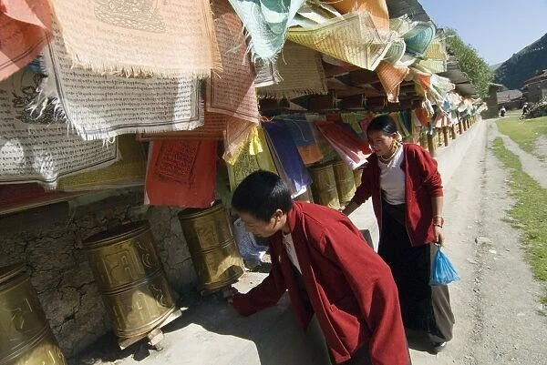 Two women turning prayer wheels, Tagong temple, Tagong, Sichuan, China, Asia