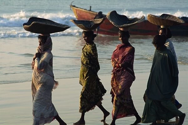 Women using turtle shells to carry fish on their heads