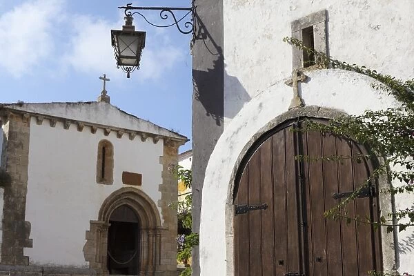 Wooden door of St. Peters Church (Igreja de Sao Pedro) in the walled medieval town of Obidos, Estremadura, Portugal, Europe