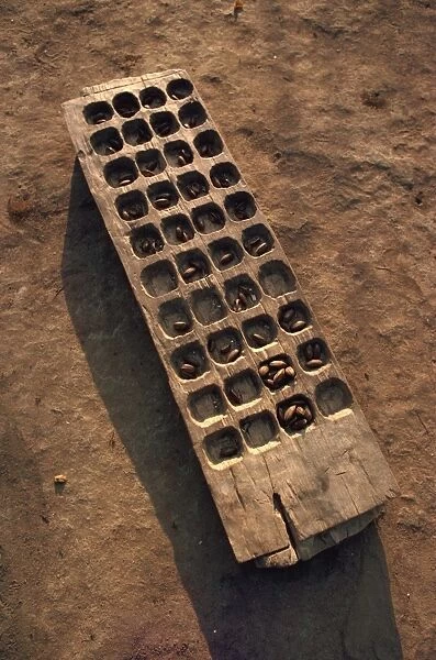 Wooden gaming board (houri) and dried beads, Maridi village, Sudan, Africa