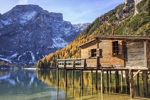 Wooden hut and colourful woods reflected in Lake Braies, Natural Park of Fanes Sennes