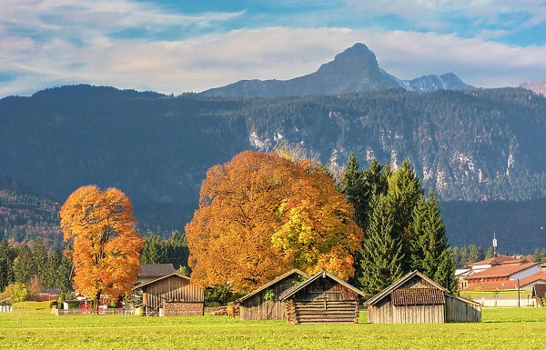 Wooden huts surrounded by colorful trees in autumn, Garmisch Partenkirchen, Upper Bavaria