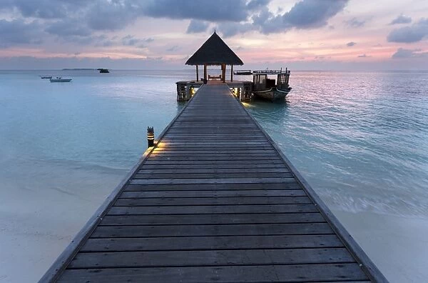 Wooden jetty and boat at sunset, Coco Palm Resort, Dhuni Kolhu, Baa Atoll, Republic of Maldives