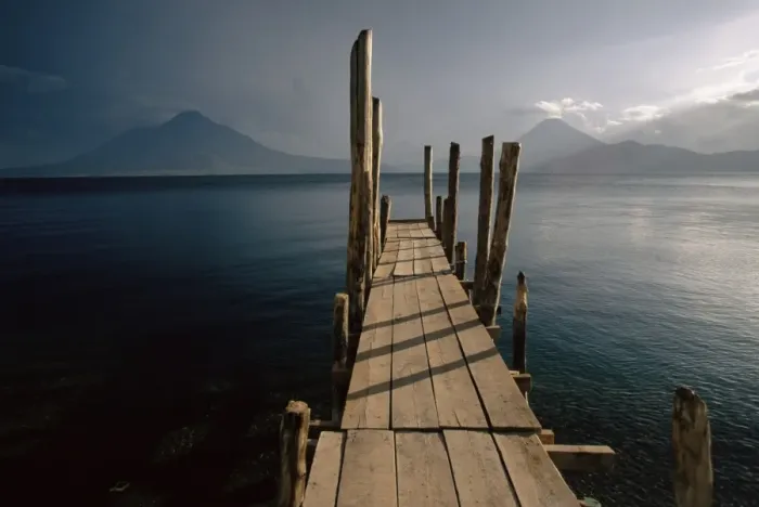 Framed Print : Wooden jetty and volcanoes in the distance Framed Print : Wooden jetty and volcanoes in the distance