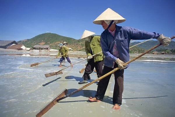 Workers with rakes at the salt mines at Cam Ranh near Nha Trang