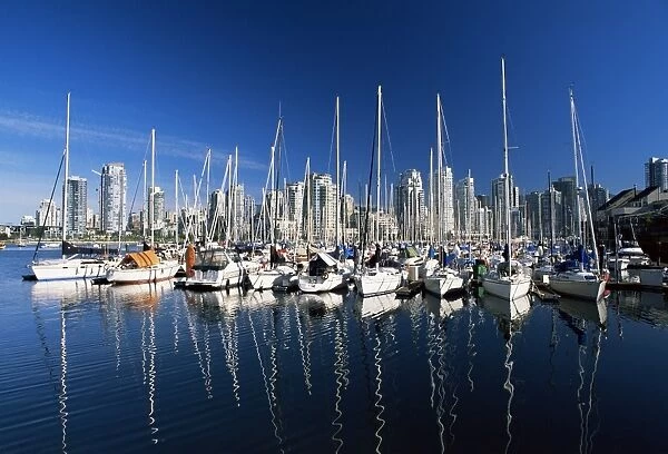 Yachts moored in False Creek marina, with downtown skyscrapers behind, Vancouver