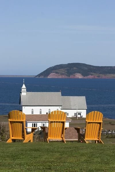 Yellow Adirondack chairs overlooking church on an island in the Gulf of St